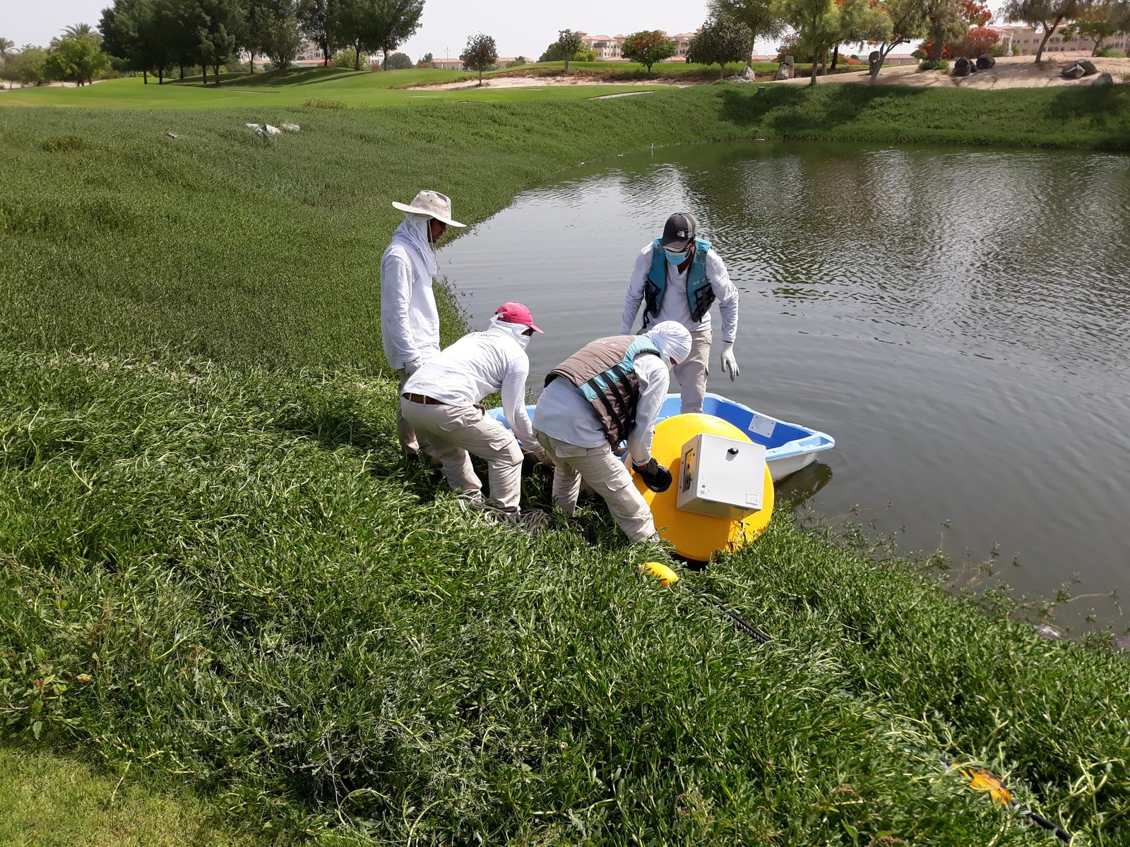 Alpha team deploying a floating aeration buoy at a golf-course lake in the UAE